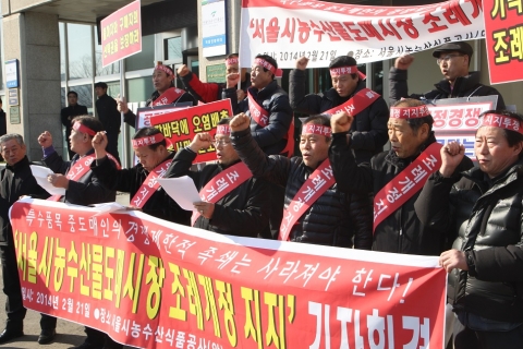 특수품목중도매인연합회 회원들이 서울시농수산물공사 앞에서 기자회견을 갖고 있다. 특수품목중도매인연합회 이계수 회장이 성명서를 낭독후 기자회견에 참가한 회원들과 함께 구호를 외치고 있