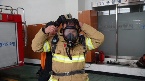일산 킨텍스의 소방안전관리자를 맡고 있는 김종진 차장이 일산소방서 대원에게 공기호흡기 착용법을 배우고 있다.
