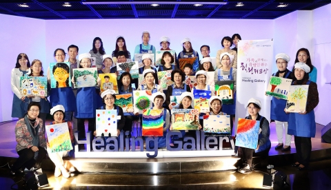 한국로슈 힐링 갤러리 시즌 4에 참가한 유방암 환우와 그 가족들이 자신이 완성한 그림을 들고 기념촬영을 하고 있다