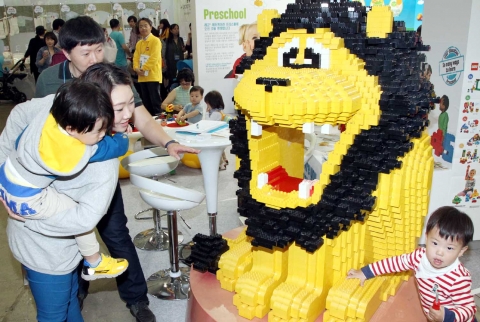 코리아베이비페어 완구특별전에 전시된 사자 모형의 레고를 아이들이 신기하게 쳐다보고 있다.
