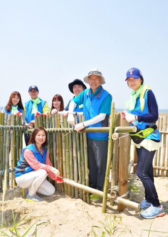 한국암웨이 박세준 대표와 직원들이 태안해안국립공원 내 기지포∙상봉 해수욕장에서 해안 방제 펜스를 설치하고 있다.