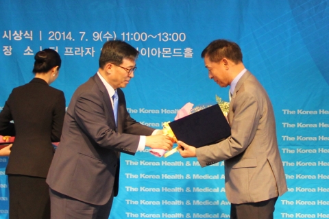 KMI 이규장 이사장(오른쪽)이 김춘진 국회보건복지위원장으로부터 상장과 수상패를 전달받고 있다.