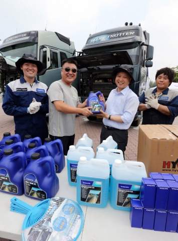 볼보트럭코리아가 14일 신탄진휴게소(상행선)에서 개최한 2014 볼보트럭 여름서비스캠프에서 김영재 사장(오른쪽에서 두 번째)이 고객에게 엔진오일을 전달하고 있다.