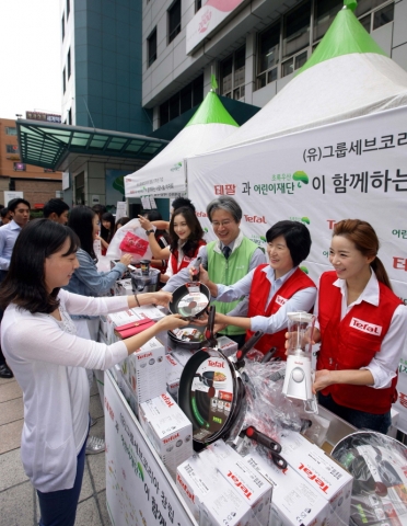 9월 18일 무교동 어린이재단 본부 앞 광장에서 진행된 테팔, 사랑나눔 바자회에서 팽경인 테팔 대표 및 직원들과 이충로 초록우산 어린이 재단 본부장이 제품을 판매하고 있다.