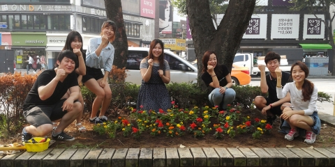 건국대 학생들이 지난 27일 오전 서울 광진구 능동로 지하철 건대입구역 인근 도로변 자투리 땅에 꽃을 심고 있다.