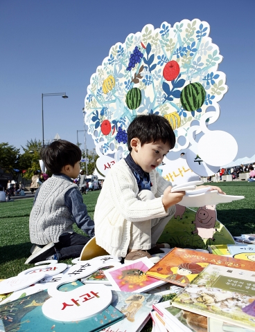 5일 광화문 세종대로 보행자 전용도로 위에 깔린 인조잔디 위에서 어린이들이 상상나무에 글자 카드를 걸고 있다. 신기한 한글나라 입체 놀이는 놀잇감으로 한글의 원리를 익히는 놀이 중심 한글 프로그램이다.