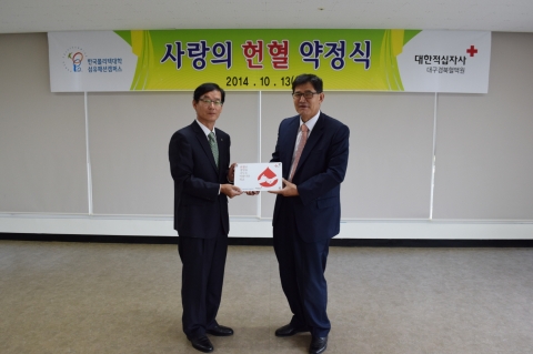 헌혈로 생명을 나누는 학교 명패를 전달하고 있다.