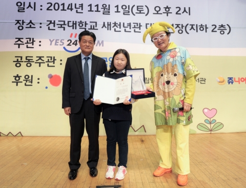 개인상 부문 대상을 수상한 경기 고양 신촌초등학교 5학년 이윤서 양이 예스24 김기호 대표와 사회자와 함께 기념 촬영을 하는 모습