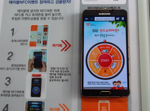 NFC를 설정하고 테이블 위에 올려놓아 이벤트에 응모하는 모습이다.