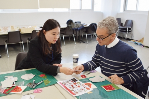 도우미학생이 party flag제작을 돕고 있다.