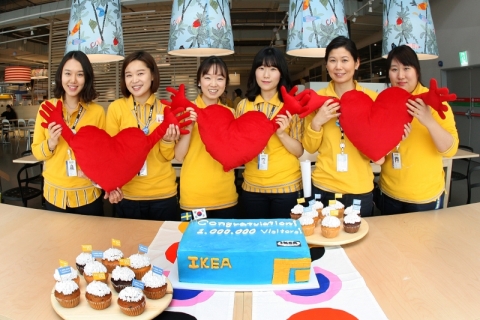 이케아 코리아 직원들이 100만 번째 방문객을 맞아 기뻐하고 있다.