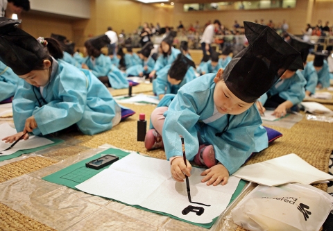 어린이들이 부모들이 지켜보는 가운데, 김봉곤 훈장의 가르침에 따라 효에 대해 배운 후 부자유친을 서예로 직접 써보고 있다.