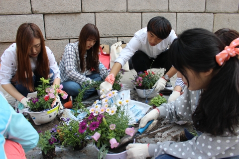 서울시설공단에서 준비한 다양한 재활용 화분에 꽃을 심고 있다