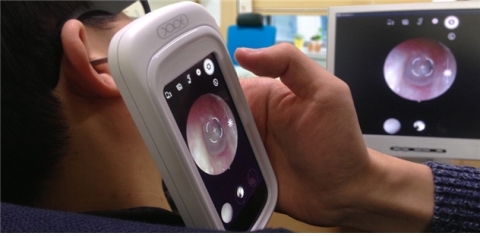 엑스코프를 이용하여 기초진료를 하고 있는 환자. 미러링이 된 모니터에서 직접 상태를 확인 할 수 있다.