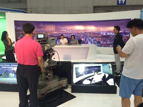 SBS와 함께하는 방송체험전에 참가한 관람객들이 뉴스앵커 체험을 즐기고 있다.