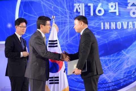 티모넷 IT Mobile 부문장인 정희원 부사장(사진 오른쪽)이 황교안 국무총리로부터 대통령 표창을 받고 있다