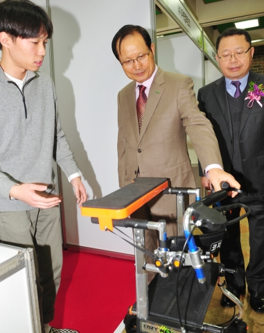 건국대 창업지원단의 2015 KU창업한마당에서 송희영 건국대 총장이 대학생 창업기업 코지케어의 노약자용 성인보행기 코지워크(Cozy Walker) 제품을 살펴보고 있다