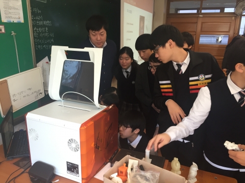 3D프린터를 가까이서 보며 신기해 하는 중학교 학생들