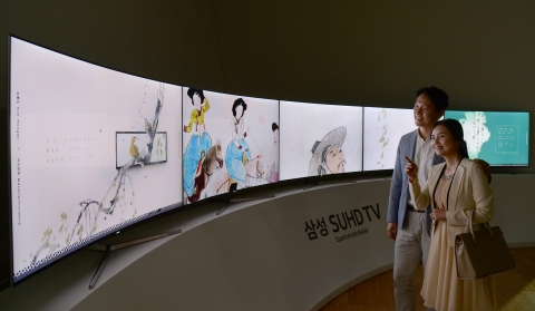 삼성전자 모델들이 아름다운 색감과 종이의 질감까지 생생하게 전달해주는 퀀텀닷 삼성 SUHD TV를 통해 조선후기 최고의 풍속인물화로 선정된 작품들을 감상하고 있다
