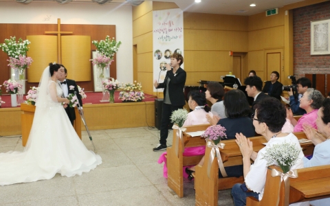 가수 정희주씨가 25일 홀트에서 11년만에 탄생한 장애인 부부 전복남· 김히경씨의 결혼식 축가를 부르고 있다