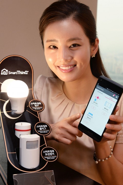 서울 영등포구 여의대로 LG 트윈타워에서 모델이 스마트 전구, 스마트 플러그, 모션센서 등 사물인터넷 연동기기 3종을 소개하고 있다