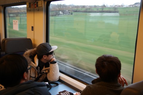 스위스 기차 안에서 평화로운 초원을 바라보며 생각에 빠진 아이들