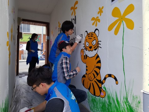 한국보건복지인력개발원 부산교육센터 봉사단원들이 호천마을 벽화 만들기 사업을 실시하고 있다