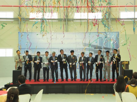 지엠아이그룹 임직원들이 성공적인 공장 오픈식을 축하하며 테이프 커팅을 하고 있다