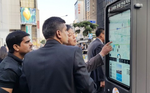 외국인 관광객들이 IoT 스마트 안내판을 사용하고 있다