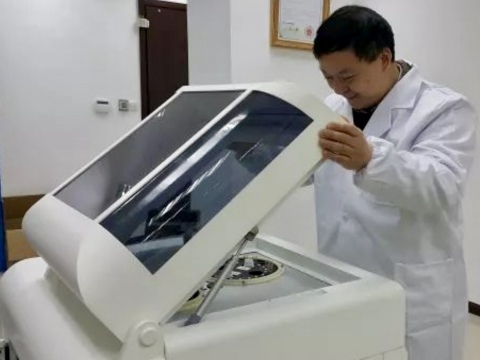 안팩 바이오의 최고경영자 크리스 유 박사가 간단한 표준 혈액검사에 앞서 회사의 암차별화 분석 액체 생체 검사기기를 점검하고 있다