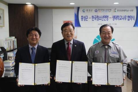 업무협약을 실시하는 김석환 홍성군수(가운데), 한국청소년연맹 한기호 총재(오른쪽), 그리고 홍성생태학교 나무 모영선 이사장(왼쪽)