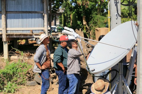 Engineers installing a satellite antenna in a rural location in Thailand