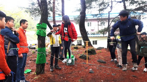 국립평창창소년수련원 야외 활동 전문 지도자가 문경새재유스호스텔에서 연수 참가자들에게 숲 밧줄 놀이 방법을 교육하고 있다