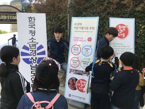 한국청소년경남연맹이 진행하는 캠페인에 청소년들이 배려와 나눔(희망사과나무)에 대한 설명을 듣고 있다