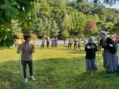 충북 음성의 꽃동네사랑연수원에서 찾아가는 청소년지도자 전문연수 숲밧줄놀이 과정에 참여한 연수생들이 밧줄 매듭법을 배우고 있다