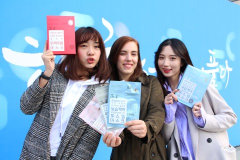 한글날을 앞두고 서울 광화문 광장을 찾은 이들이 한글 포장 마스크팩을 선물 받고 기뻐하고 있다