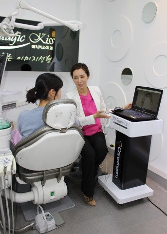 Dr. Yumi Jung is explaining gum and mouth condition to patients through digital scanning