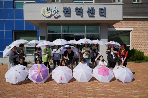 GREAT 홍천 팸투어 참가자들이 무궁화마을에서 무궁화 우산만들기와 짚풀공예를 마치고 단체사진을 찍고 있다