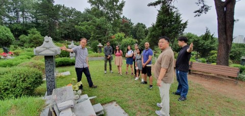 민주화운동기념사업회 2019 자원활동가 하계 워크숍- 자원활동가 워크숍에 참여한 참가자들이 마석 모란 공원 민주열사묘소 중 전태일 묘소에서 사업회 양금식 국장의 설명을 듣고있다