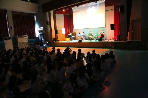 참가자들이 초등학교 문화예술체험으로 찾아가는 음악회 - 애니메이션 음악회를 감상하고 있다