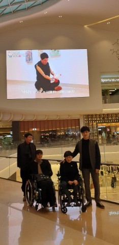 한국장애예술인협회가 개최하는 장애인예술로 아름다워지는 대한민국 참여 작가들이 대형 전광판 앞에서 기념촬영을 하고 있다