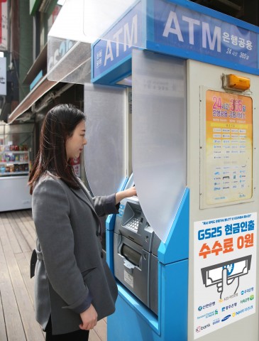 고객이 GS25에서 ATM 서비스를 이용하고 있다