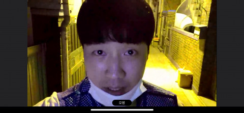 배우가 SKT 5G 휴대폰을 들고 골목으로 나가 연극을 하고 있다