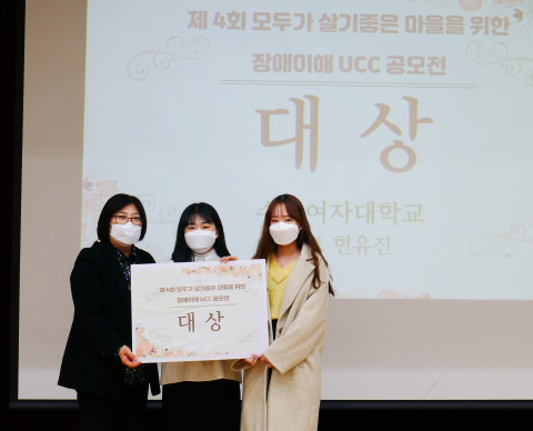 왼쪽부터 호매실장애인종합복지관 안은경 관장과 공모전 대상 수상자인 수원여자대학교 학생들이 기념 촬영을 하고 있다