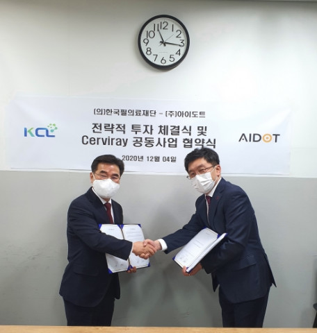 왼쪽부터 한국필의료재단 김성호 이사장과 아이도트 정재훈 대표가 날인 뒤 악수를 하고 있다