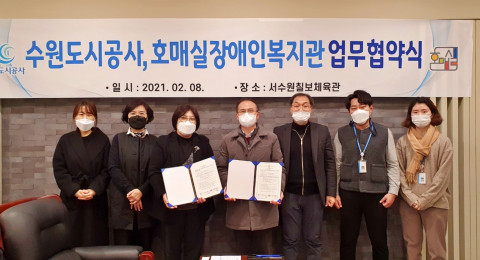 왼쪽부터 호매실장애인종합복지관 직원 3명과 수원도시공사 직원 4명이 함께 협약식에서 기념 촬영을 하고 있다