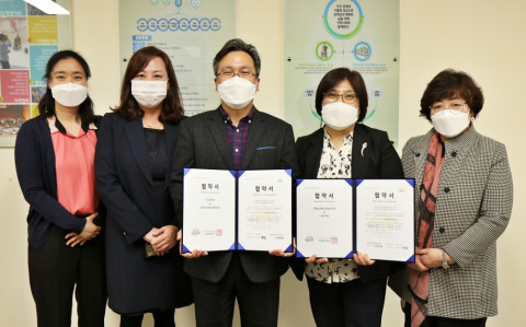 드림온학교 김영식 교장(왼쪽부터 세 번째)과 안은경 호매실장애인종합복지관 관장(왼쪽부터 네 번째), 직원들이 협약서를 들고 함께 기념 촬영을 하고 있다