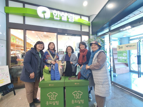 조합원과 시민들이 가져온 헌옷을 한살림 매장에 비치된 옷 모음함에 넣고 있다