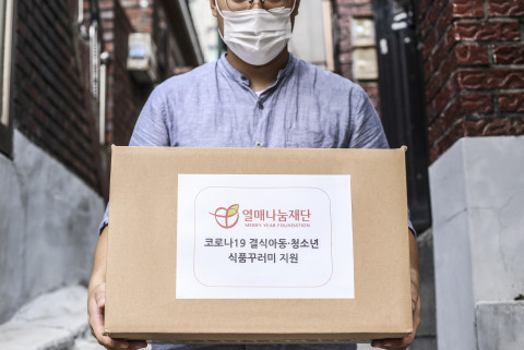 열매나눔재단 관계자가 결식 위기 아동·청소년 지원 식품꾸러미를 들어보이고 있다