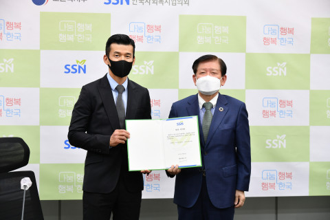 위촉 서약서를 함께 들고 있는 나눔홍보대사 션과 서상목 협의회장